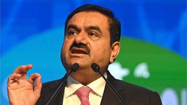 Man speaking at a podium, making a point during a conference.