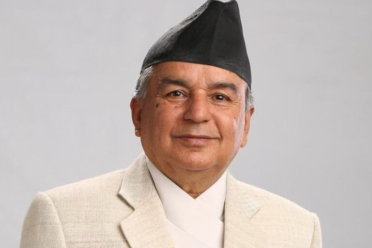 Elderly man in traditional Nepali attire with a woolen hat.