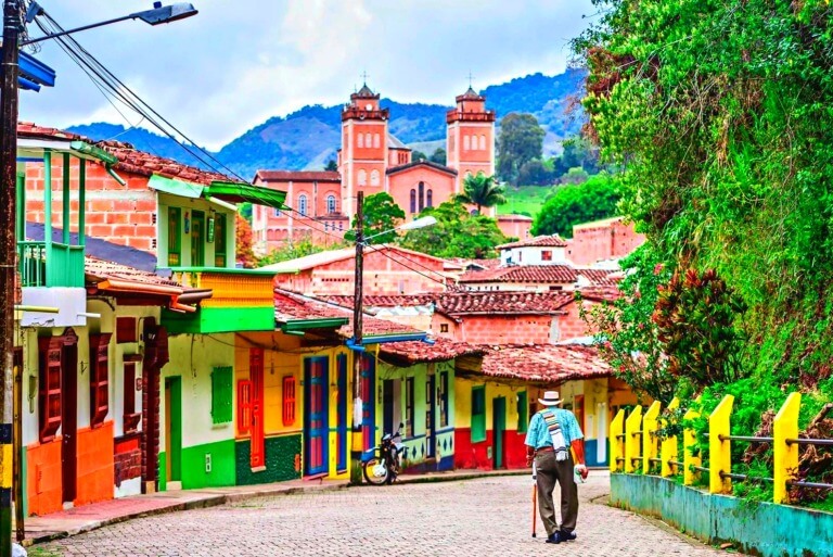 Colorful street view in Colombian town with man walking.