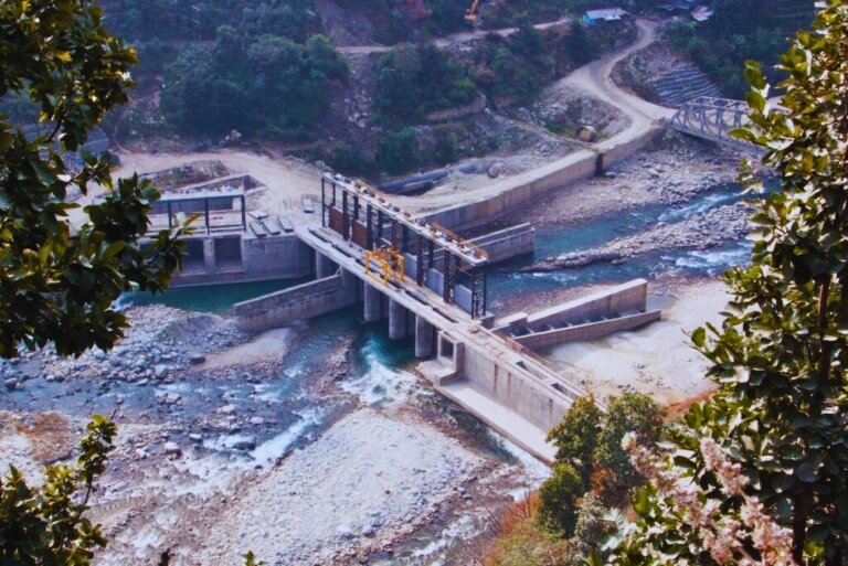 Hydropower dam surrounded by lush forest scenery.