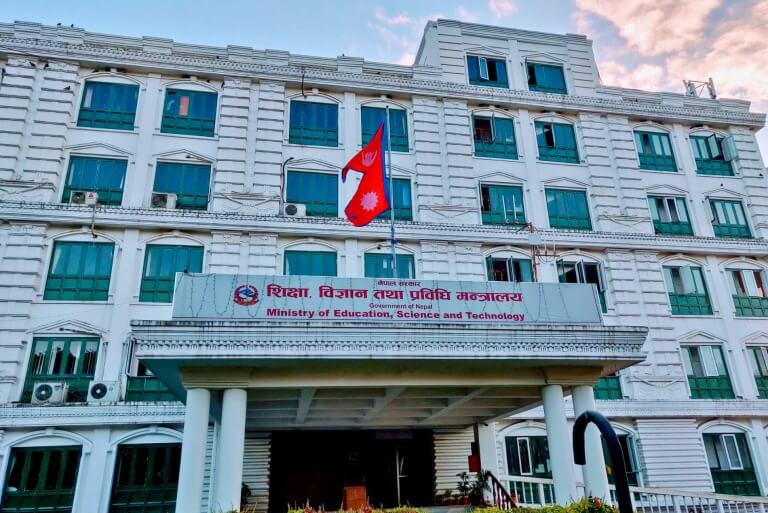 Nepal Ministry of Education building with national flag.