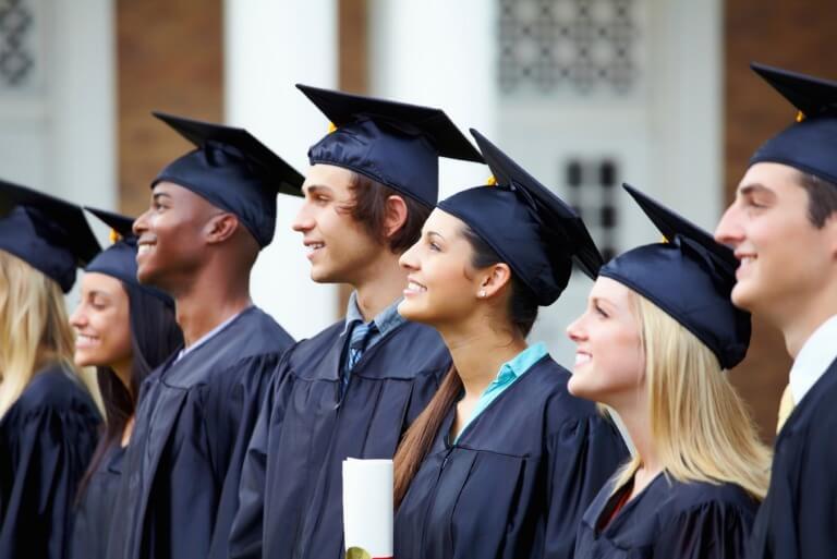 Graduates in caps and gowns smiling at ceremony