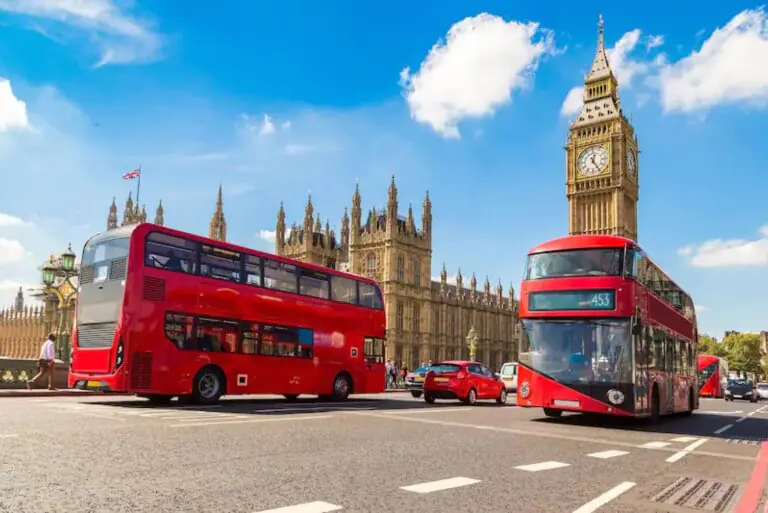 Red buses near Big Ben and Parliament, London.
