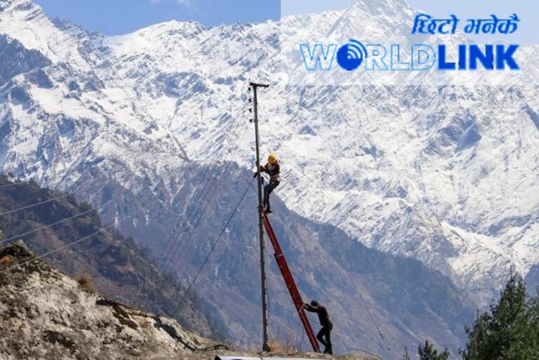 Technicians installing equipment on a pole, snowy mountains backdrop.