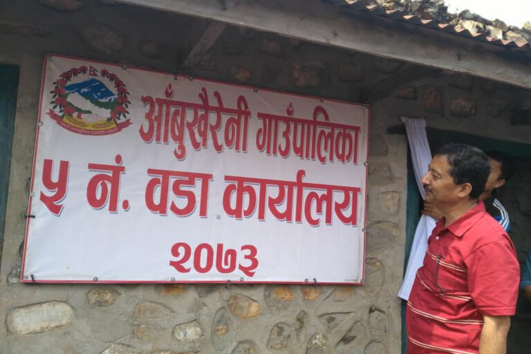 Man observing sign at Abukhaireni Ward Office, Nepal.