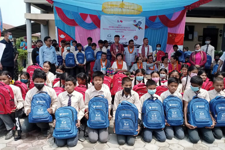 School students receive backpacks at donation event.