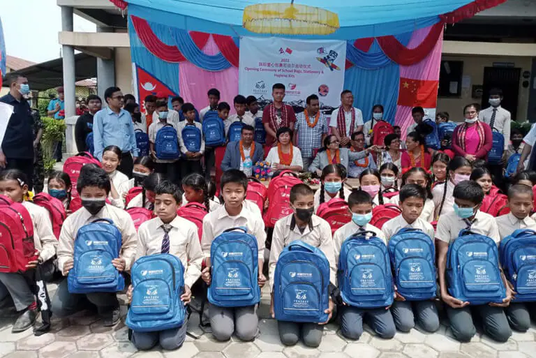 School students receive backpacks at donation event.