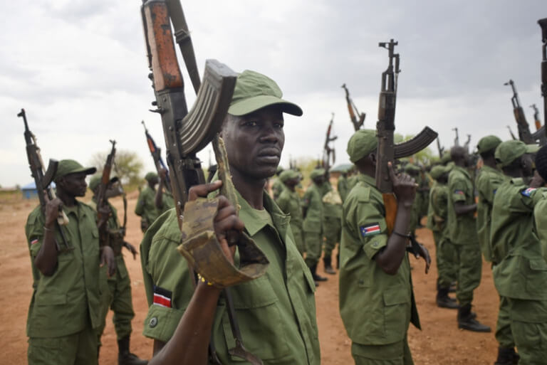 Soldiers in green uniforms holding rifles at attention.