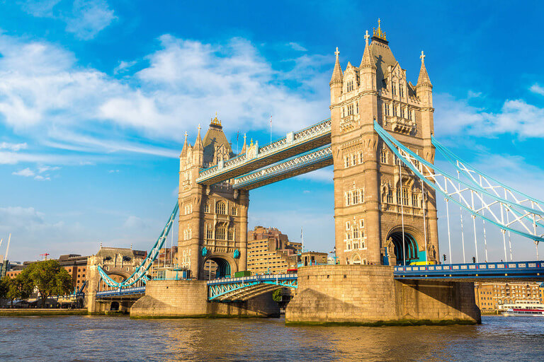 Tower Bridge in London under a clear blue sky.