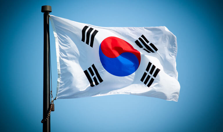South Korean flag waving against blue sky.