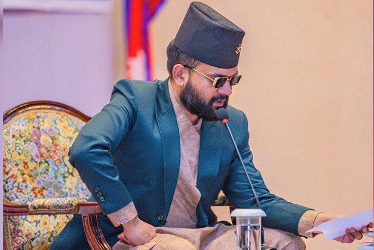 Man in traditional attire speaking at a conference.