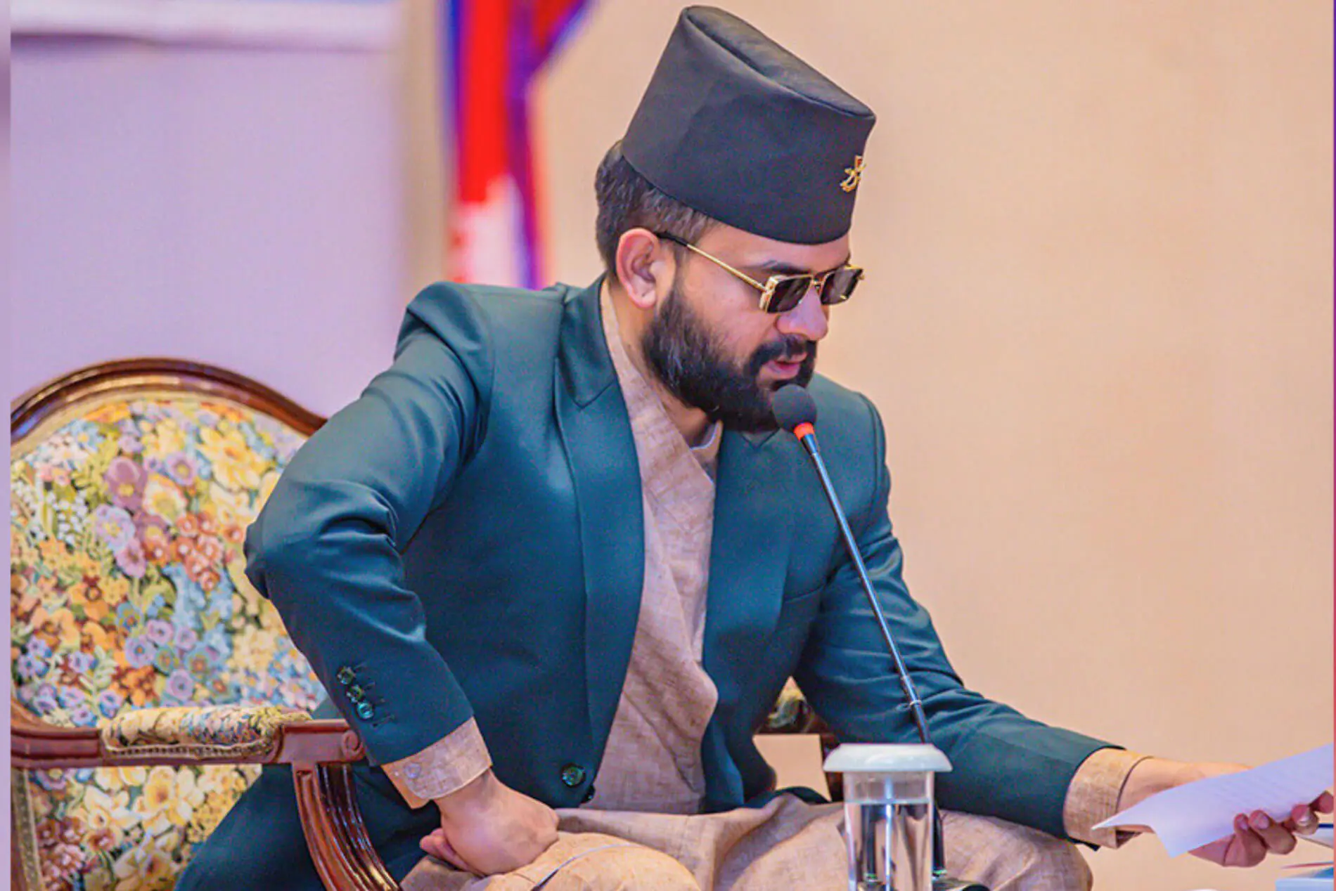 Man in traditional attire speaking at a conference.