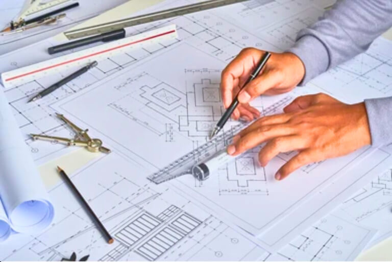 Architect drafting plans with compass and ruler.