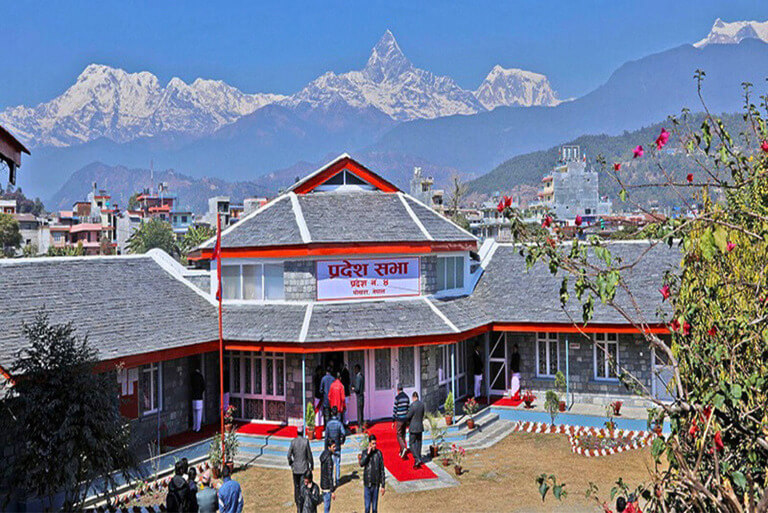Pokhara building with mountain backdrop, vibrant landscape.