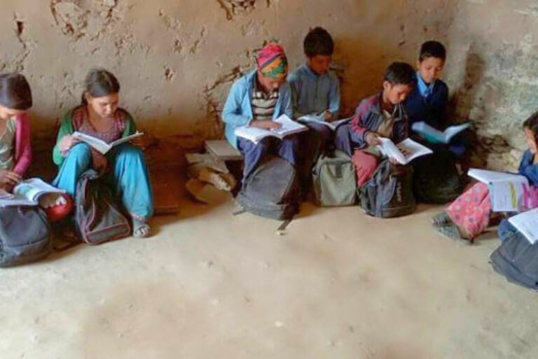 Children reading books in rural classroom setting.