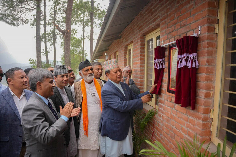 Man unveiling plaque at brick building ceremony.