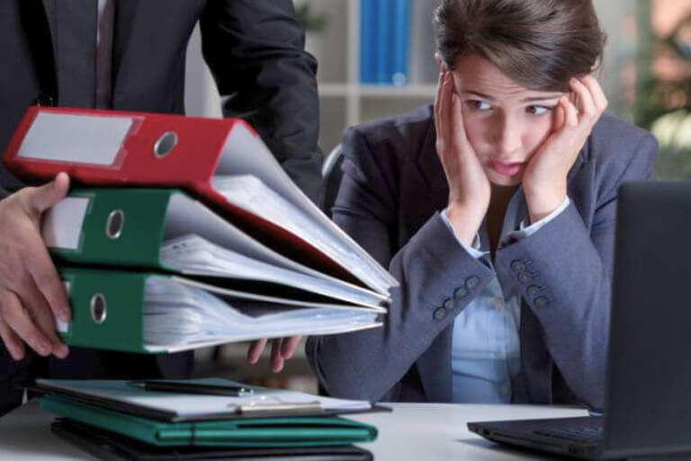 Stressed businesswoman overwhelmed by paperwork.