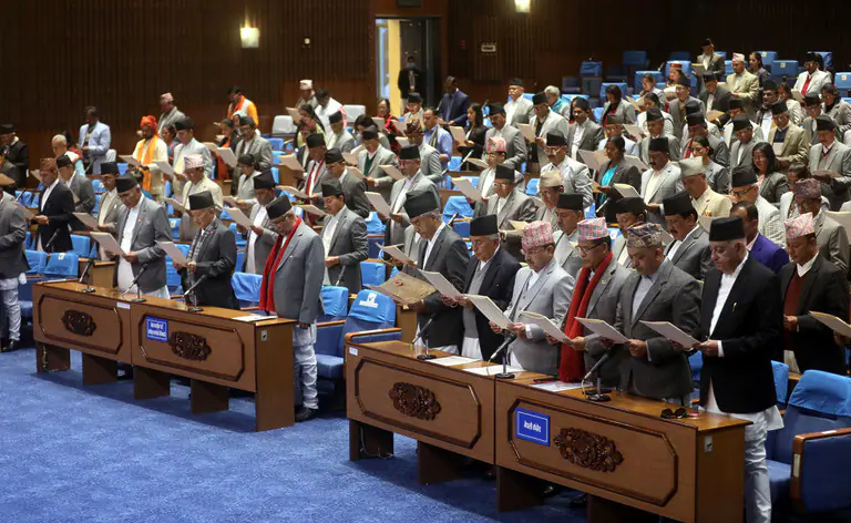 Nepal parliament members taking oath in assembly hall.