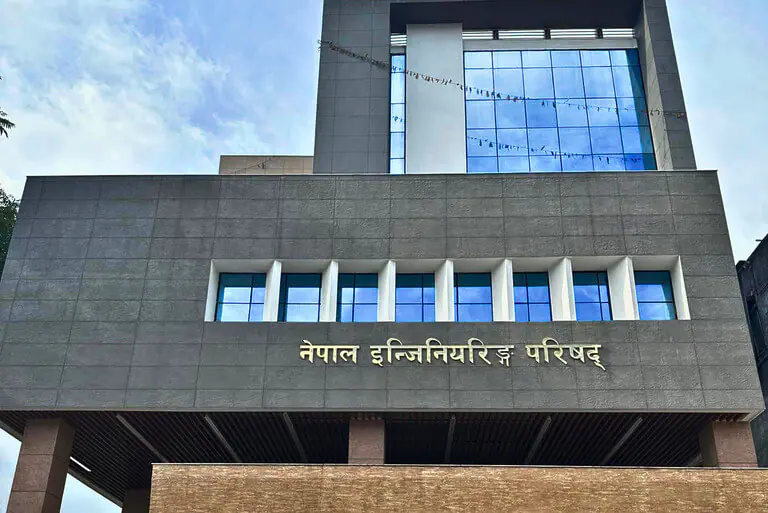 Modern building with blue windows and Nepali signage.