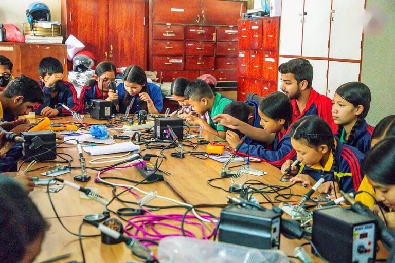 Students engaged in electronics workshop activities.