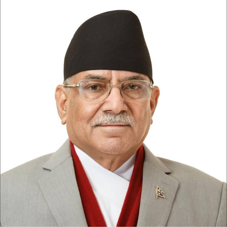 Man in traditional Nepali attire with a topi and glasses.